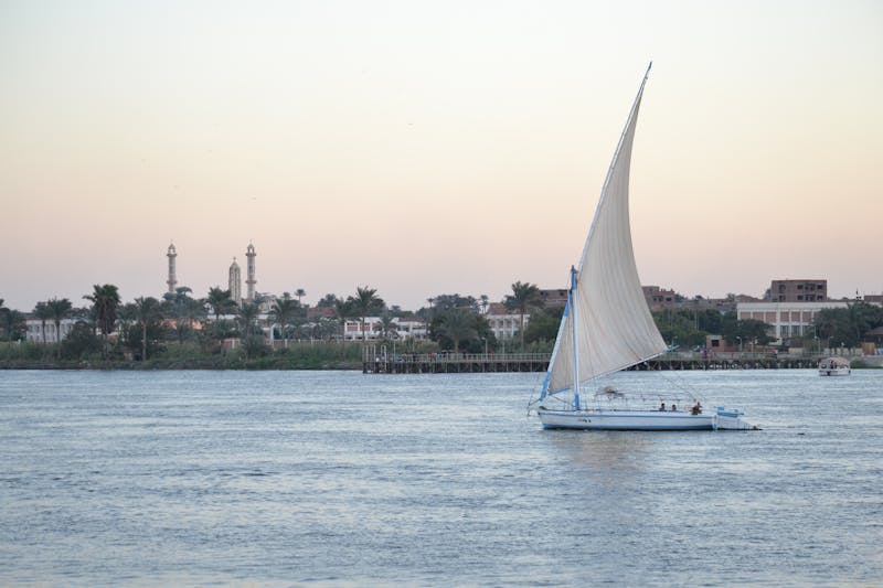 Traditional felucca sailing on the Nile River at sunset